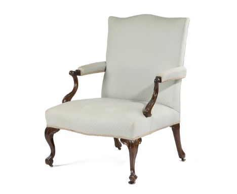 AN EARLY GEORGE III LIBRARY ARMCHAIR C.1760-70 with a serpentine back, above a padded seat and armrests, the arms carved with