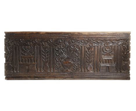 A CARVED WALNUT PANEL 16TH CENTURY decorated with a central urn of flowers flanked by cypress trees, tulips and architectural