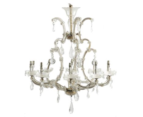 A GLASS ELEVEN-LIGHT CHANDELIER EARLY 20TH CENTURY of open scroll form, applied with flowerheads and hung with drops and sphe