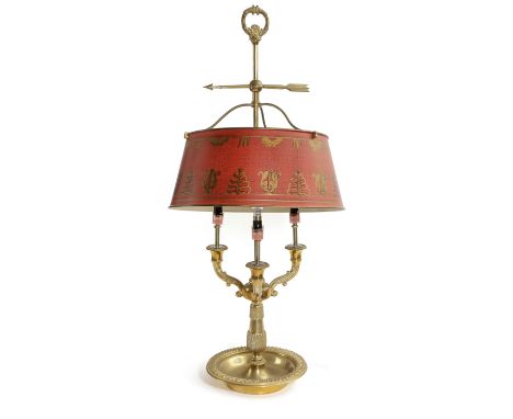 A FRENCH GILT BRASS BOUILLOTE LAMP IN LOUIS XVI STYLE with a loop handle and arrow, above a red painted tole shaped, three sc