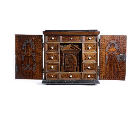 λ A NORTH ITALIAN CEDAR POKER AND PENWORK TABLE CABINET 17TH CENTURY AND LATER with a pair of doors, decorated with a fort an