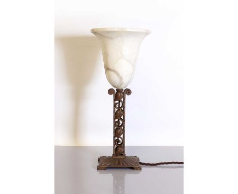 An Art Deco alabaster and patinated table lamp,with a tulip-shaped shade, raised on a pierced scrolling leaf column, on a squ