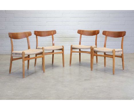 A set of four Danish oak and teak 'Model CH23' chairs,designed in 1950 by Hans Wegner for Carl Hansen, each with a woven pape