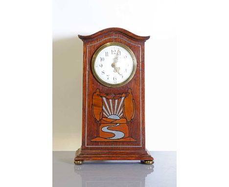 An oak-inlaid and pewter-mounted mantel clock,c.1900, the enamelled dial with Arabic numerals, the front inlaid with a stylis