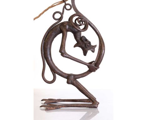 A French wrought-iron 'Grotesque' table lamp,modelled as an ogre with its body and tail coiled to the frame, the stand its kn