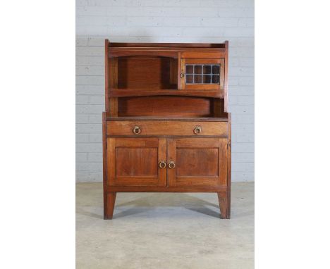 A Liberty &amp; Co. walnut bookcase,late 19th/early 20th century, with a three-quarter gallery, a shelf with a leaded glass c