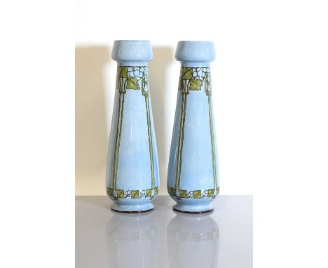 A pair of Doulton Lambeth faience pottery vases,each of slender tapering form, with a light blue glaze with Art Nouveau styli