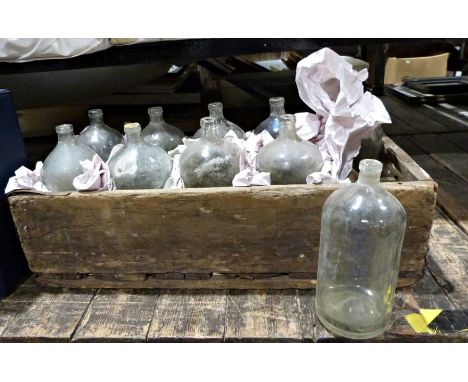 Ten vintage bottles held within a wooden carrier, probably decorative purposes only, with deliberate dis-stressing
