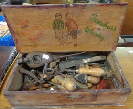 An old Teachers Whisky advertising box containing assorted vintage tools incl oil cans, scrapers, etc.