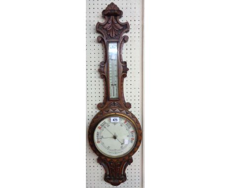 A Victorian ornate carved oak cased banjo barometer/thermometer with printed scale and dial, pierced lower section and aneroi