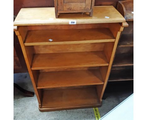 A 26 1/2" golden oak four shelf open bookcase, set on rounded plinth base