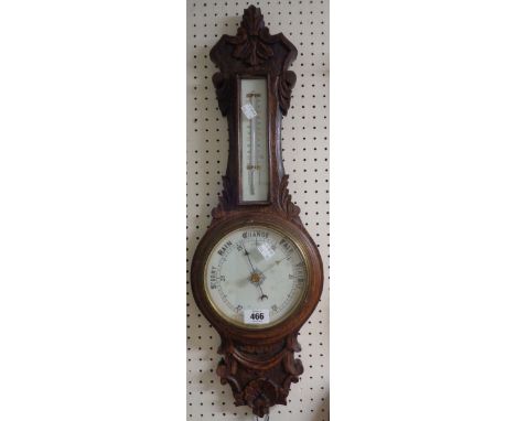 A late Victorian carved oak cased banjo barometer/thermometer with printed scale and dial and aneroid works - some staining