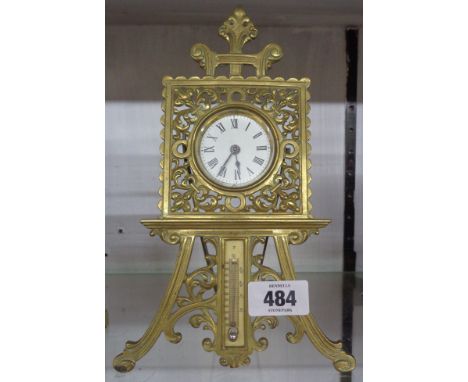 An old cast brass easel timepiece with movement marked for The British United Clock Co., with thermometer scale under