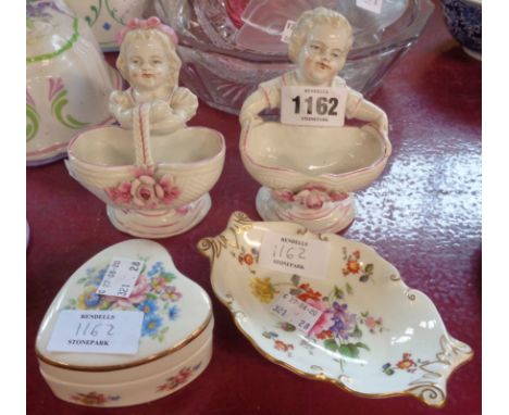 A pair of continental porcelain figural salts depicting children holding baskets, a Royal Crown Derby pin dish, and a bone ch