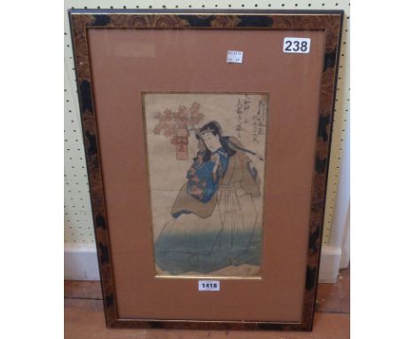 A lacquered framed Japanese wood block print, depicting a figure carrying a flowering branch with prayer - bearing stamp and 