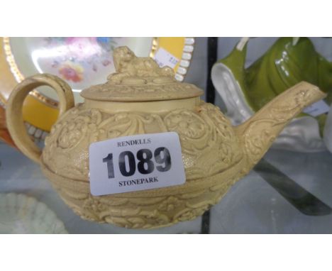 A 19th Century Wedgwood cane ware relief moulded teapot in the Rococo style with spaniel finial to lid - crack to base