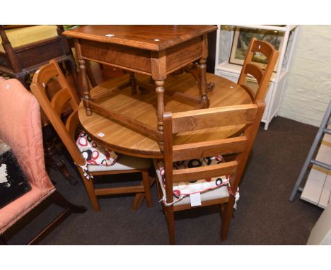 Circular oak extending dining table and four ladder back chairs