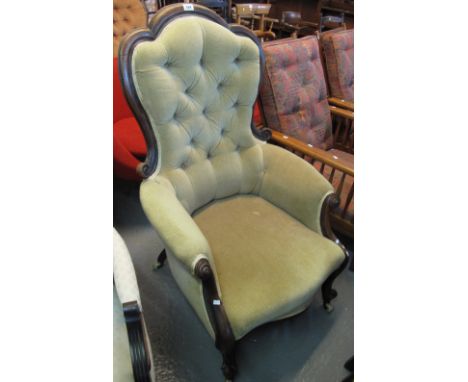 Victorian walnut upholstered show frame button back fireside armchair on ceramic casters. (B.P. 24% incl. VAT)