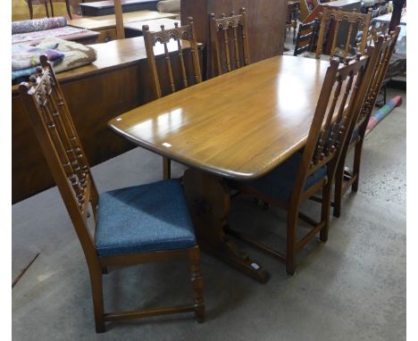 An Ercol Golden Dawn elm eight piece dining suite, comprising; refectory table six chairs and a dresser 