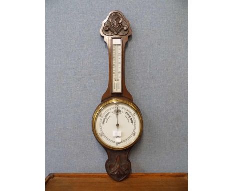 An early 20th Century carved oak aneroid barometer 