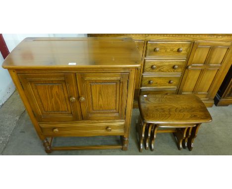 An Ercol Golden Dawn elm cabinet and a nest of tables 