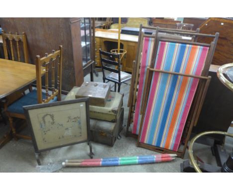 A pair of sun loungers, vintage suitcases and a fire screen 