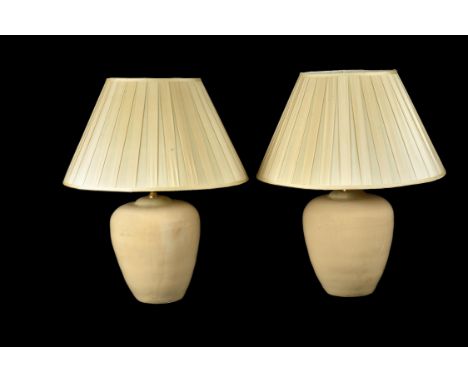A pair of glazed ceramic table lamps, modern, the sand-coloured bodies of bulbous form, 42cm high to tops of fitments, exclud