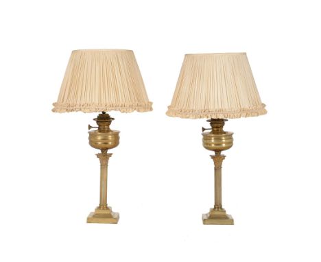 A pair of late Victorian gilt brass table oil lamps, late 19th century and converted to electricity, the burners labelled for