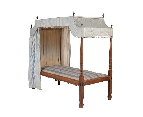 A mahogany child's four poster bed, first half 19th century, with striped upholstered canopy above turned tapering posts at t