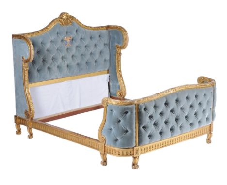 A French carved and gilded double bedstead, late 19th century, blue upholstered head and footboard, the former with embroider