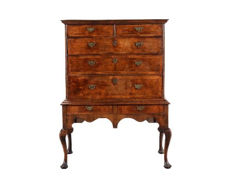 A walnut chest on stand, circa 1710 and later, with quarter veneered and crossbanded top, the drawer fronts decorated with fi