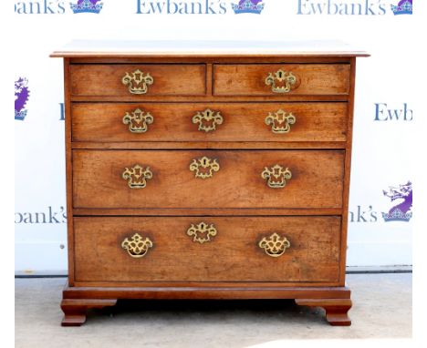 George III mahogany chest of two short over three long graduating drawers, with brass handles and escutcheons, raised on late