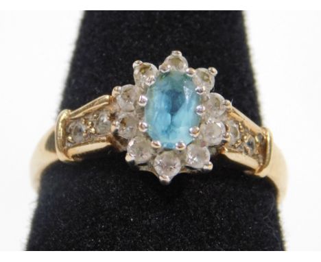 A 9ct gold dress ring, with central floral cluster of pale blue stones, surrounded by imitation diamonds, with paste stone se