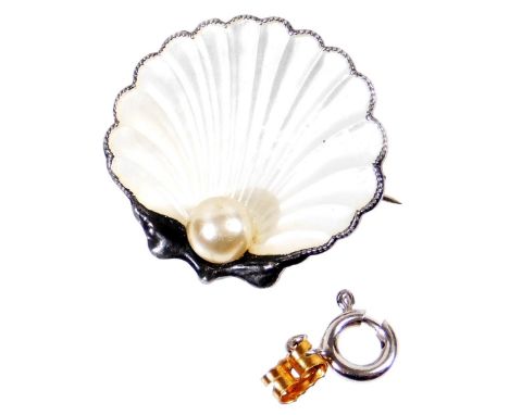 A silver and white enamel clam brooch, set with single cultured pearl to base, shaped as a clam with white enamel decoration,