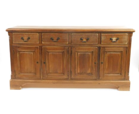 A 20thC pine dresser base, the overhanging top raised above four drawers and panelled cupboards beneath, on ogee bracket feet