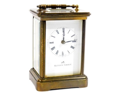 A 20thC Matthew Norman carriage clock, in brass case with swing handle, raised above a five part glazed section, with 5.5cm R