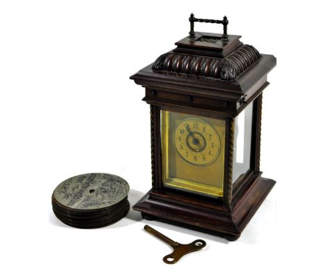 A Edwardian walnut mantle clock disc symphonium, with park gadrooned square top above a four part glazed case, on shaped base