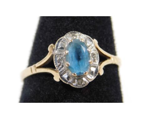 A 9ct gold dress ring, with central section, set with pale blue aquamarine stone, surrounded by tiny diamonds, in platinum se