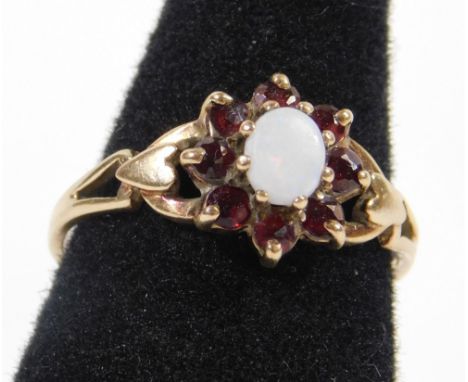 A 9ct gold cluster ring, set with central oval opal, surrounded by eight round brilliant cut garnets, with heart and pierced 