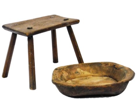An early 20thC rustic dough bowl, of shaped form, 43cm W and a pegged stool.  (2)