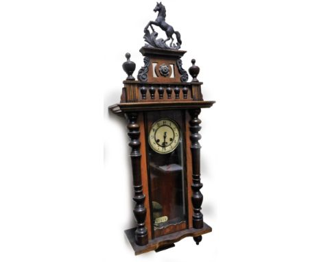 A early 20thC walnut cased Vienna wall clock, surmounted with horse finial, on a pierced and scroll plinth flanked by urns, a