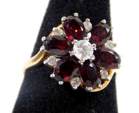 A 9ct gold floral cluster ring, set with oval cut garnets, and CZ stones, in raised twist design ring head, ring size R, 4.3g