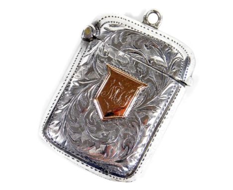A Victorian silver vesta case, of oblong form, engine turned with a yellow metal engraved shield, match strike base and ring 