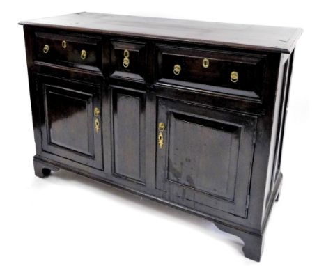 An 18thC oak dresser base, the top with a moulded and cleated ends above an arrangement of three panelled frieze drawers abov