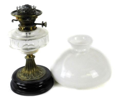 A Victorian brass oil lamp, with later opaque shade, clear faceted glass reservoir and tapering base with black ceramic plint