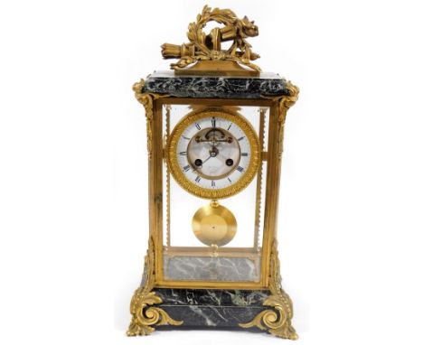 A 19thC French mantel clock, with elaborate marble gilt metal case, surmounted by quill and garland, above a four sided glass