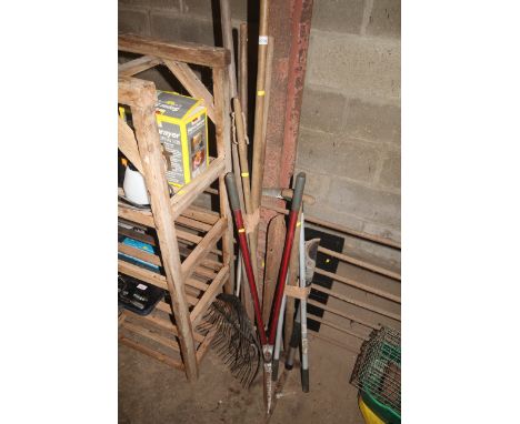A quantity of long handled garden tools to include rakes, garden shears etc.