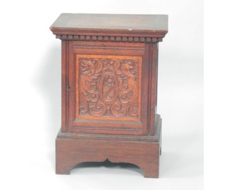 A Victorian oak smoker's cabinet, with a dentil moulded cornice, above a carved panel door, raised on bracket feet, 38cm x 28