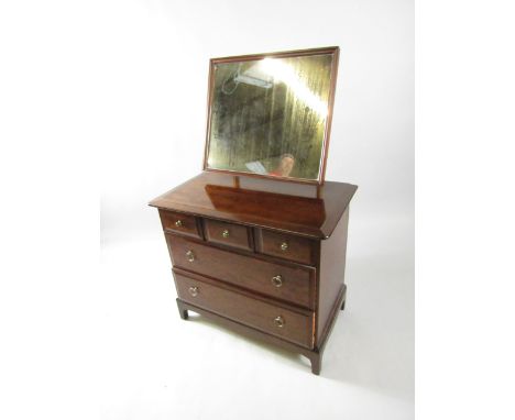 A Stag mahogany dressing chest, the rectangular framed mirror over three short and two long drawers, raised on bracket feet, 