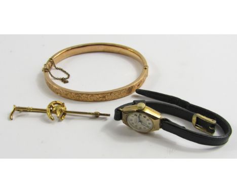 A 9ct rose gold bangle with engraved foliate decoration, on a snap clasp, 9ct gold hunting tie pin modelled as a riding crop,